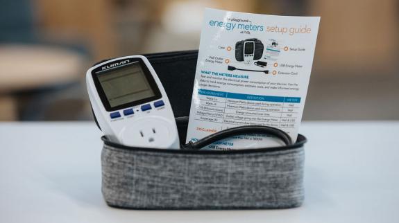 An energy meter housed in a case, positioned on a table, showcasing its sleek design.