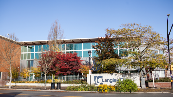 A large, window-filled building in the City of Langley, featuring the exterior of the library.