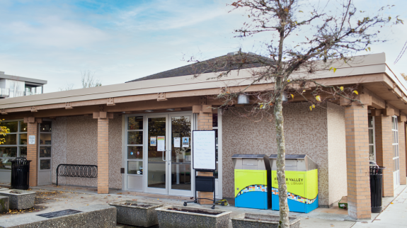 Exterior view of the Ladner Pioneer Library with a tree prominently in front of the building.