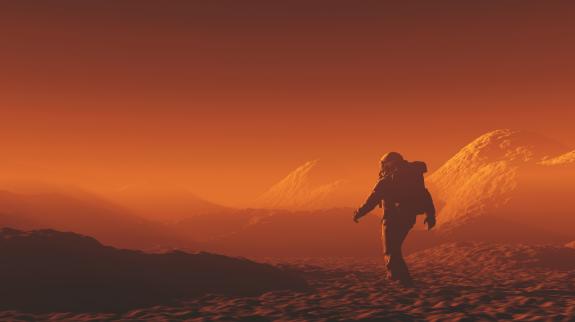 A lone figure walks on a red planet, exploring its unique terrain and vibrant, rusty hues.