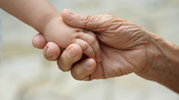 Baby girl and great grandmother's hand.