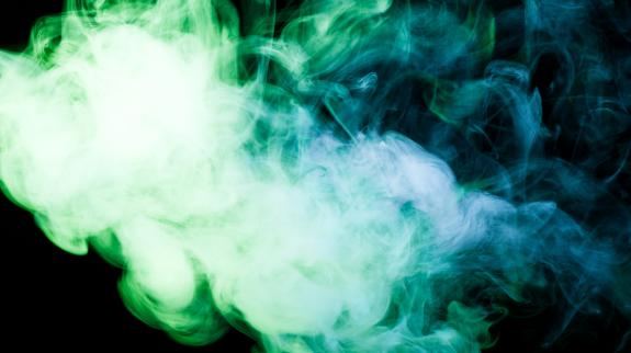 Green and blue smoke against a black background.