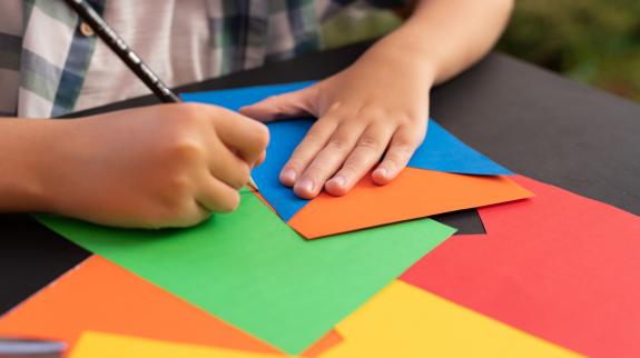 Close-up hand of child cutting banner flags.
