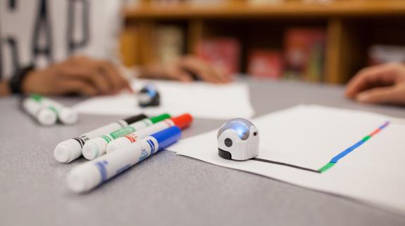 Robotic balls - Ozobots - sit on a table with marker and paper.