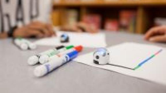 Robotic balls - Ozobots - sit on a table with marker and paper.