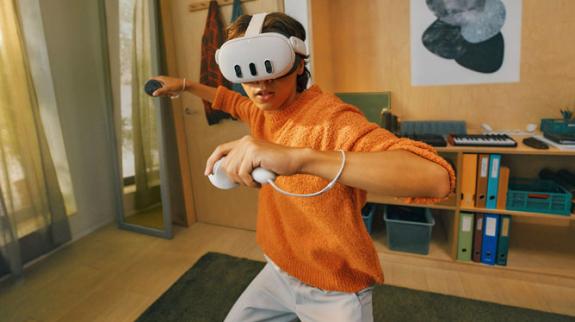 Teen using mixed reality VR headset with controllers.