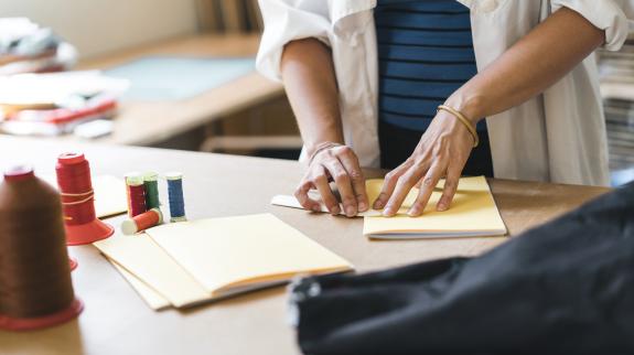Young adult woman making a notebook. Japanese binding style.