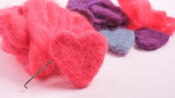 Several multi-colored felted woolen hearts.