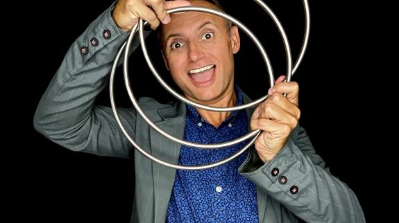Photo of magician Joe Chambers of The Jokus Pocus Magic Show posing with some props