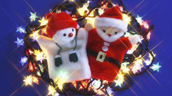 Snowman and Santa handpuppets lay in a pile of colourful Christmas lights.