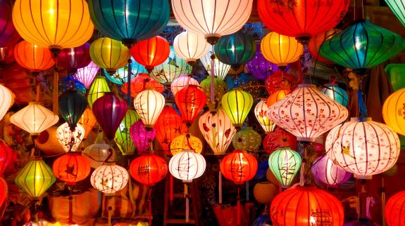 Various hanging Chinese lanterns in store front window.