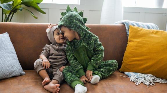 Kids in costumes at home celebrating Halloween.