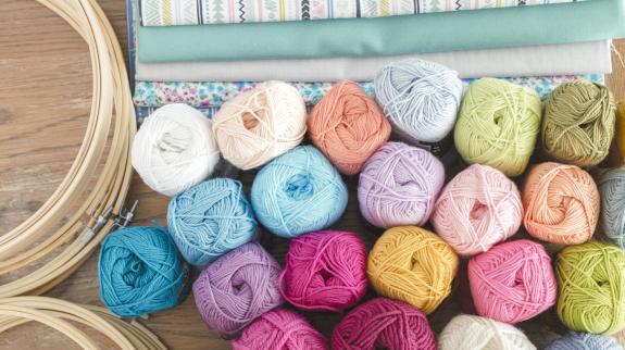 Punch needle or embroidery wool with different fabrics and hoops. Different colour and size yarn.