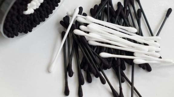 A pile of black and white cotton swabs.