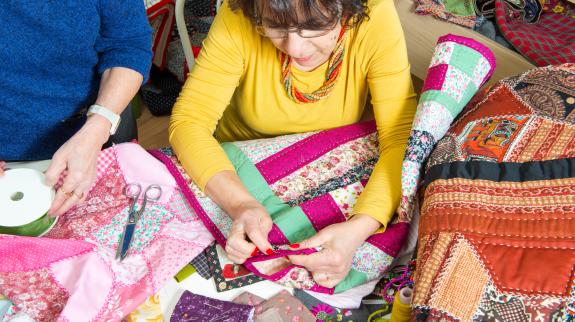 Two women working on their patchwork in a workshop.
