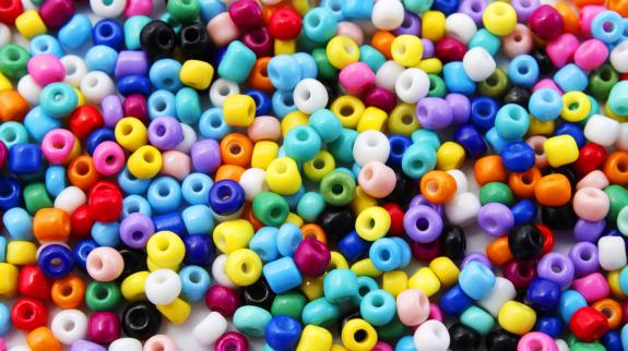 Background with many colored pony beads used to make necklaces and bracelets.