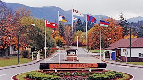 Sign at the forefront of flags signaling the Main Gate of Canadian Forces Base Chilliwack