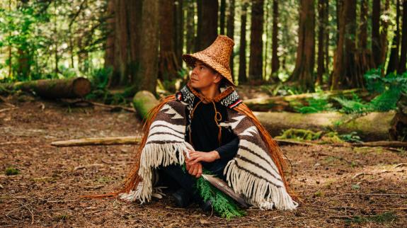 Photo of Len Pierre sitting in forest with tress in the background