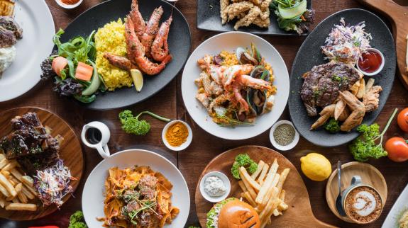 Top looking down at restaurant food spread on table.