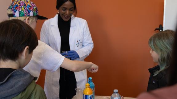 Dr Drummond running an experiment with junior scientists