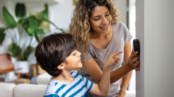 Picture of adult and child looking at thermostat 