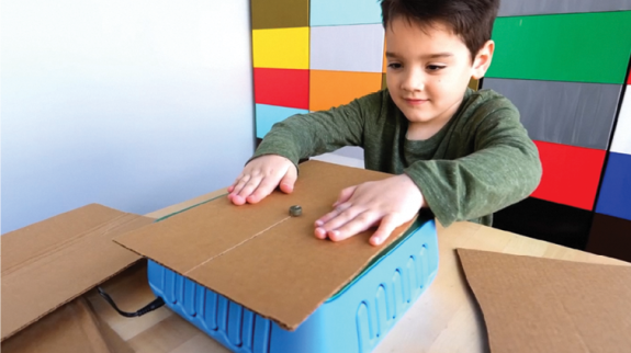 Photo of kid sawing cardboard on the ChompSaw