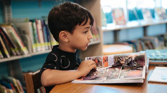 A young boy reads a graphic novel at FVRL's Terry Fox Library.