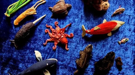 Collection of ocean-themed puppets and figurines on blue background
