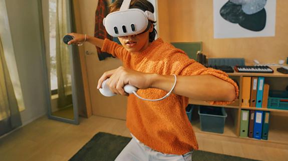 Teen using mixed reality VR headset with controllers.