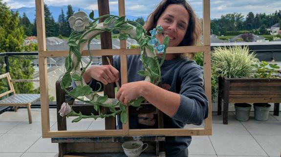 person standing behind window frame with wreath