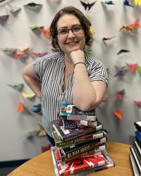 Reading Adviser Sally poses with a stack of books.