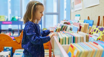Child explores a box filled with books.