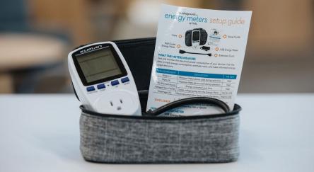 An energy meter housed in a case, positioned on a table, showcasing its sleek design.