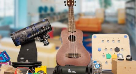 A table displaying a ukulele, telescope, and assorted playground items, showcasing a blend of hobbies and interests.