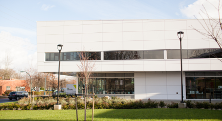 A large modern building, the Terry Fox Library, captured in an exterior photo highlighting its design and setting.