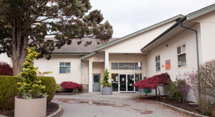 The exterior of Yarrow Library features a large tree prominently positioned in front of the building.