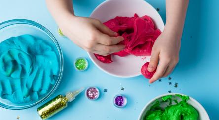 A child's hands knead vibrant play dough, creating colorful shapes and textures in a fun, creative activity.