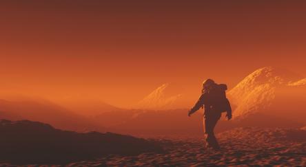 A lone figure walks on a red planet, exploring its unique terrain and vibrant, rusty hues.
