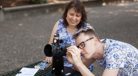 A man and woman gazing through a telescope, sharing a moment of wonder under the sky.
