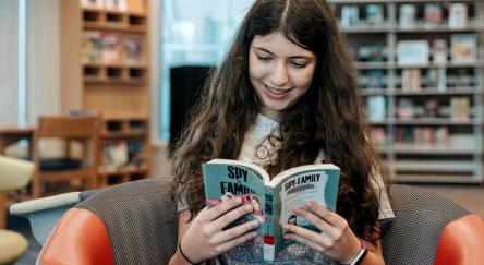 A teen girl reads a book at Maple Ridge Public Library.