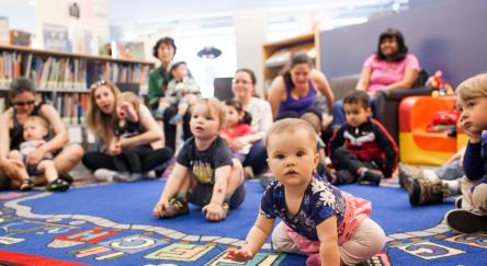 Babies and their parents suit on carpet in library for a Babytime early literacy event.