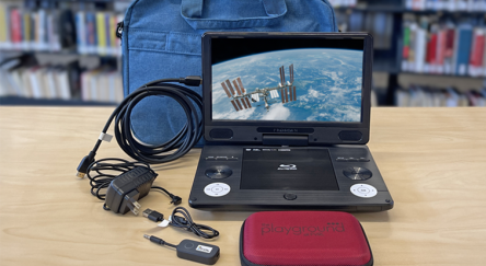 Portable blu-ray player with carrying case and accessories.