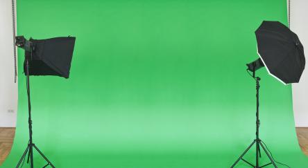 Empty green studio backdrop with softboxes.