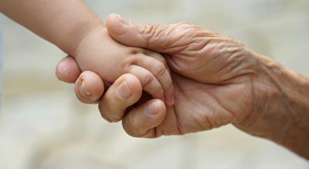 Baby girl and great grandmother's hand.
