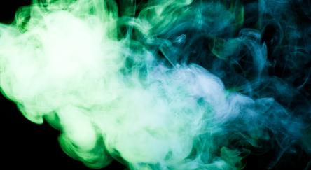 Green and blue smoke against a black background.