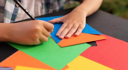 Close-up hand of child cutting banner flags.