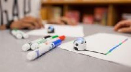 Robotic balls - Ozobots - sit on a table with marker and paper.