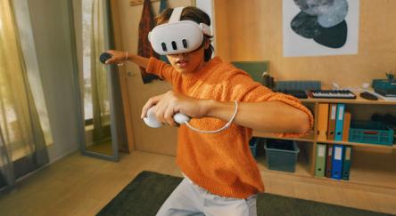 Teen using mixed reality VR headset with controllers.