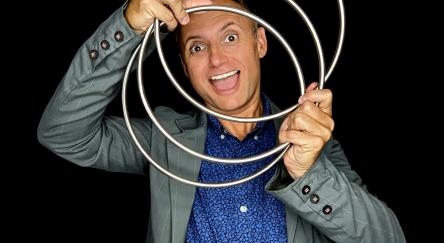 Photo of magician Joe Chambers of The Jokus Pocus Magic Show posing with some props