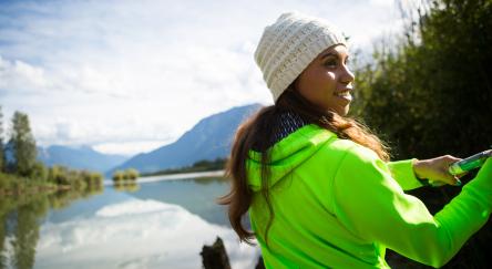 An indigenous Canadian woman standing by the river salmon fishing.